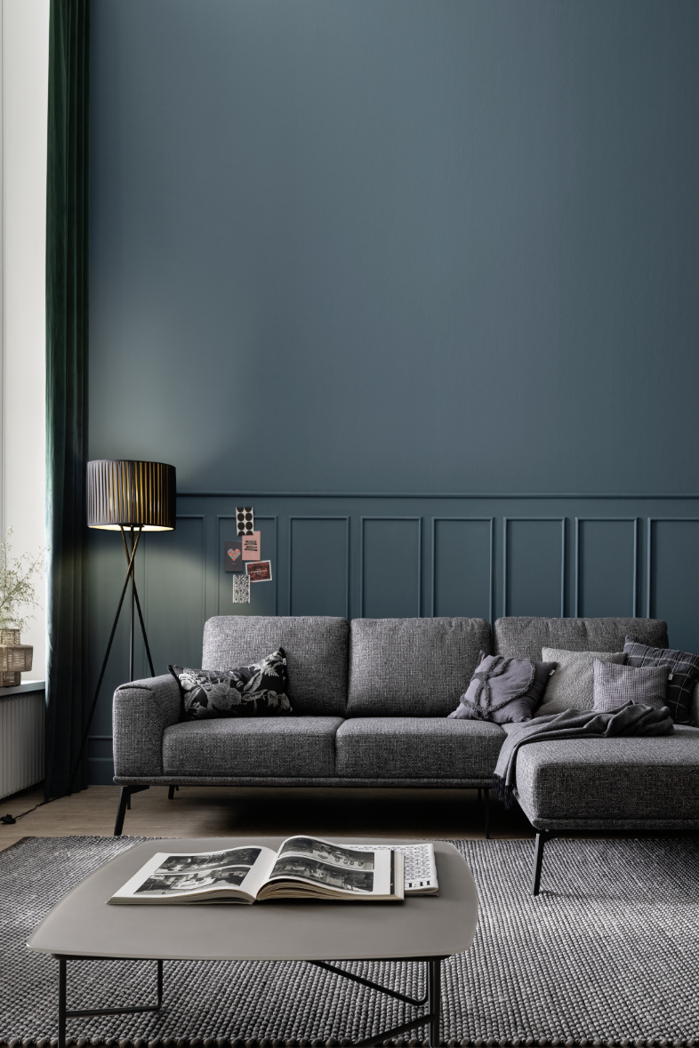 Wohnzimmer mit dunkelblauer Wandfarbe und Sofa in grau SCHÖNER WOHNEN-Wandfarben Wirkung