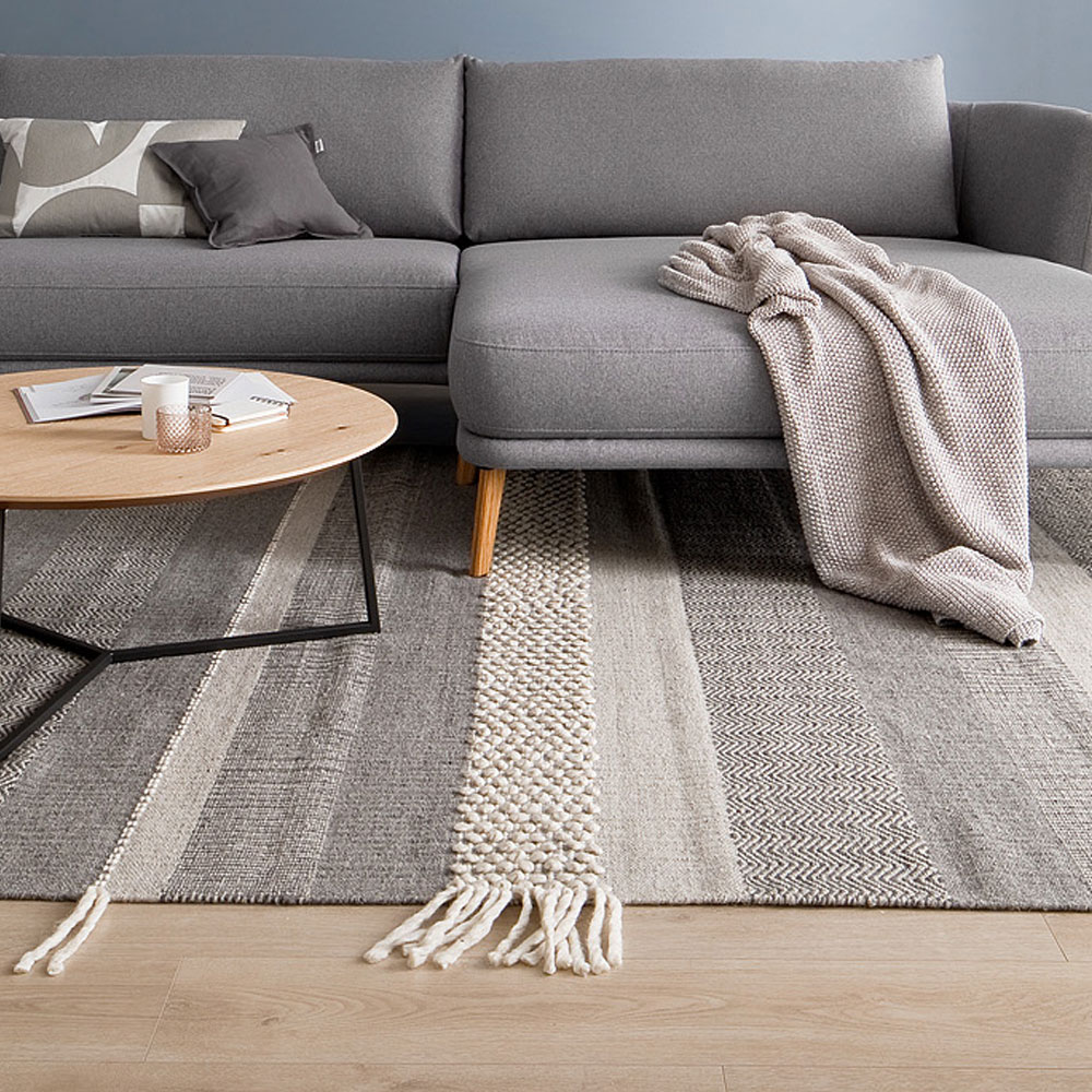 Blaues Wohnzimmer mit grauem Sofa und Teppich in beige SCHÖNER WOHNEN-Teppiche