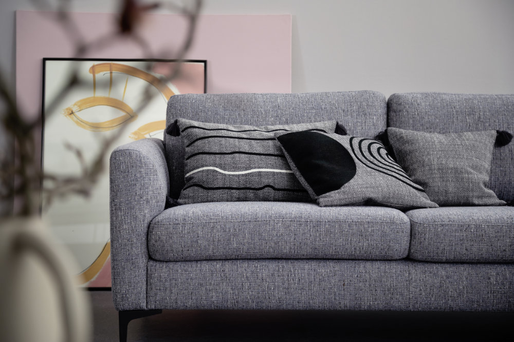 graue Kissen auf grauem Sofa SCHOENER-WOHNEN-Textilien