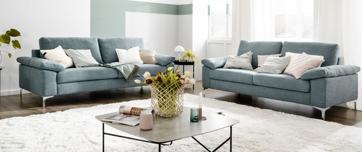 helles Wohnzimmer mit grünem Sofa SCHOENER-WOHNEN-Textilien