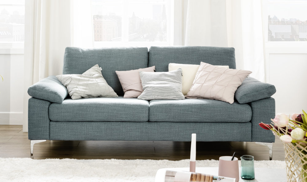 grünes Sofa mit hellen Kissen SCHOENER-WOHNEN-Textilien