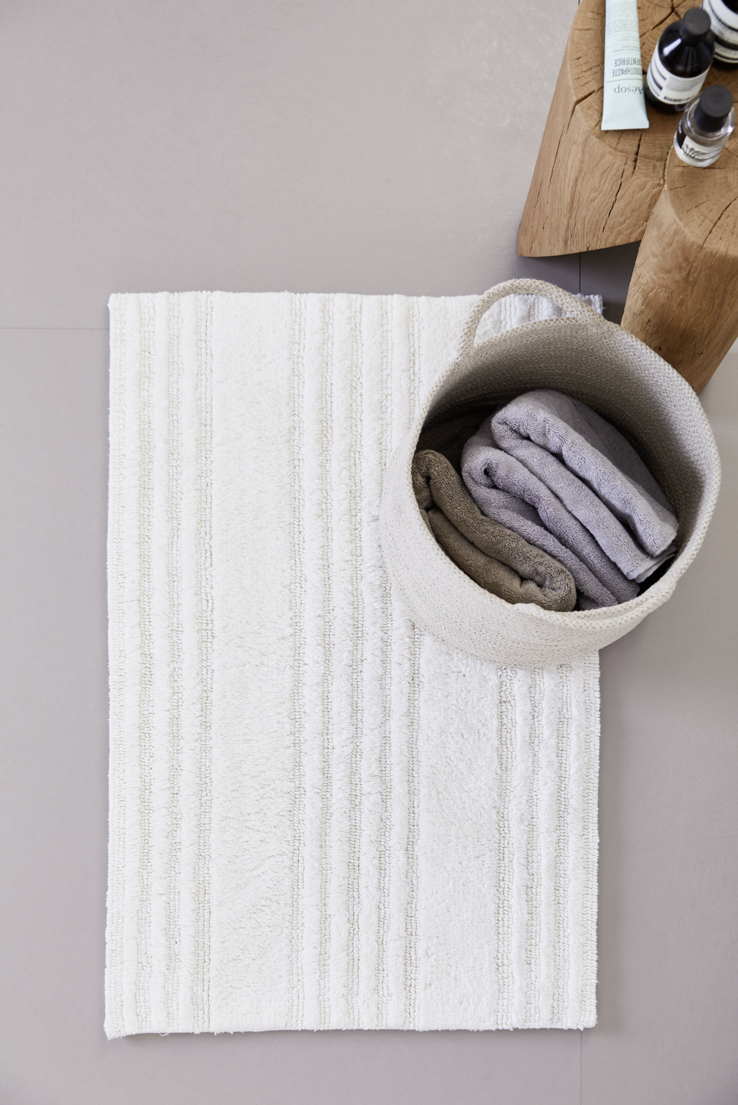Badezimmer mit hellen Fliesen und weißem Badteppich SCHÖNER WOHNEN-Badezimmer